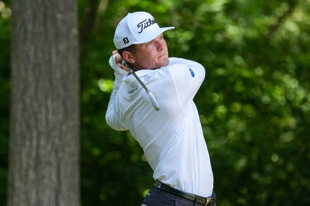 A competitor at the top of his follow-through on a tree-lined hole at Sedgefield Country Club